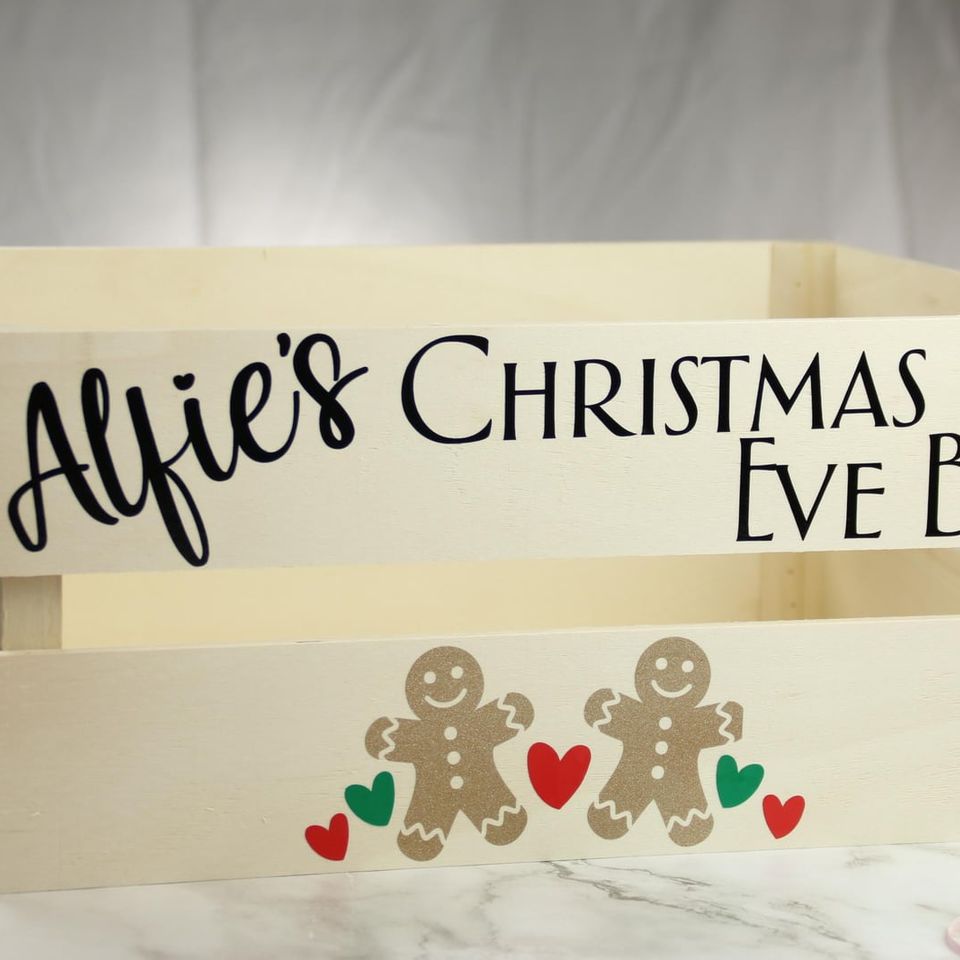 Wooden crate lettered “Alfie’s Christmas Eve Box” with gingerbread figures and hearts