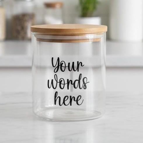 Glass jar with a bamboo lid, lettered “Your words here” in black script