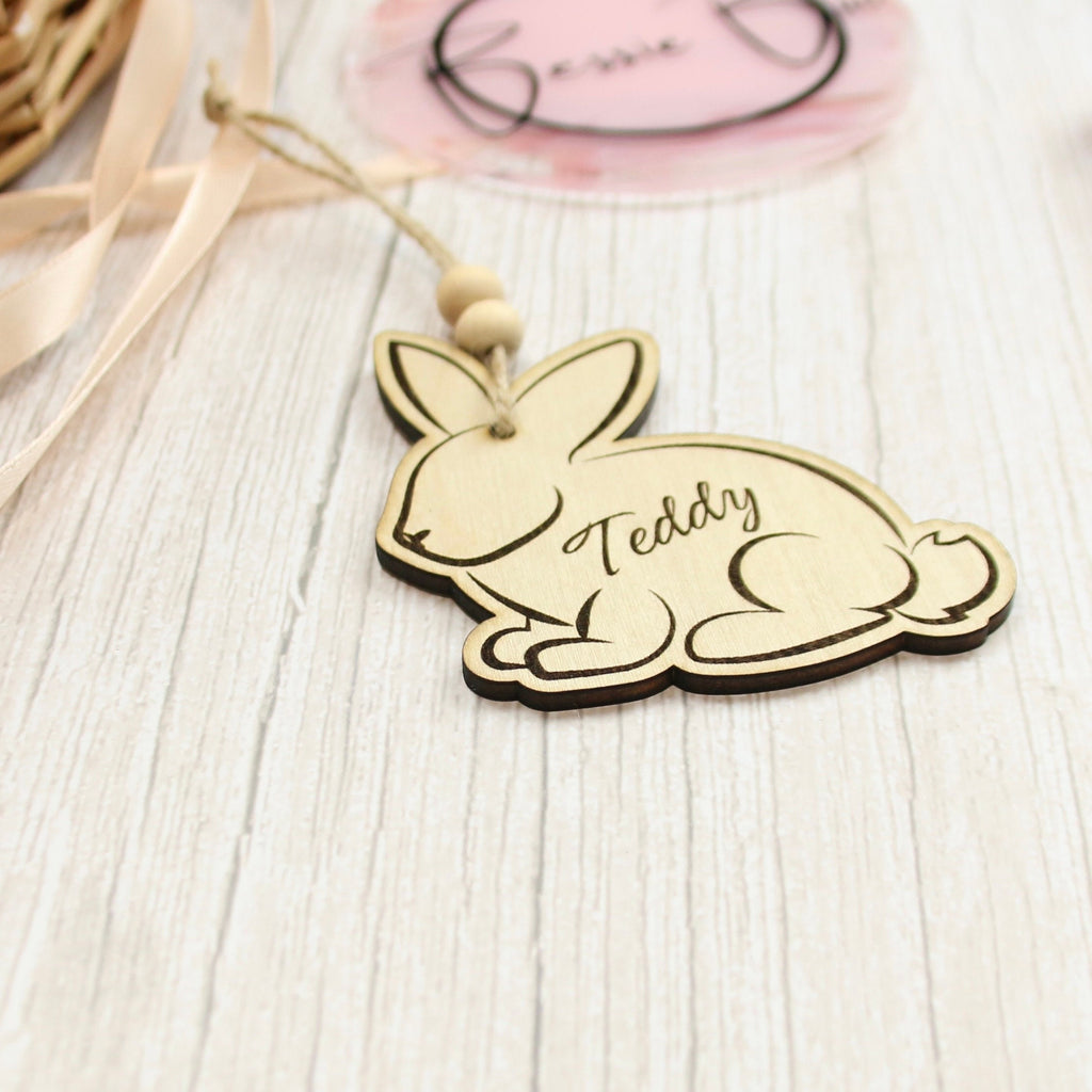 Easter basket wooden tag to be used as an Easter Decoration. The tag is in the shape of a bunny made from 3mm Plywood beautifully cut by laser. The item includes personalisation options, such as the name of a child. The image says &#39;Teddy&#39;.