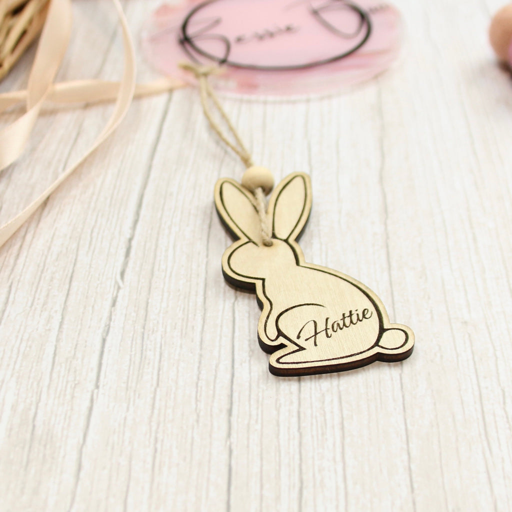 Easter basket wooden tag to be used as an Easter Decoration. The 8cm tag is in the shape of a bunny made from 3mm Plywood beautifully cut by laser. The item includes personalisation, such as the name of a child. The image says &#39;Hattie&#39;.